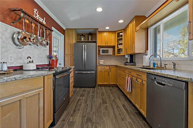 kitchen with dark wood-type flooring, crown molding, sink, light stone countertops, and appliances with stainless steel finishes