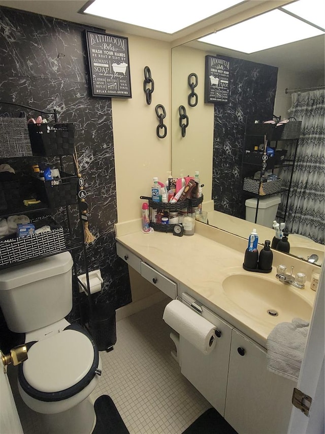 bathroom featuring tile patterned floors, vanity, and toilet