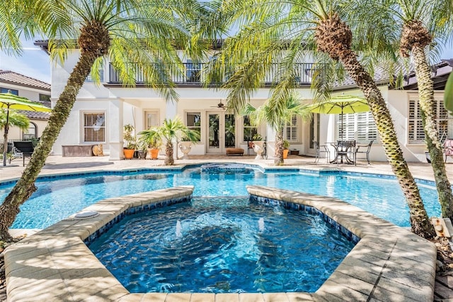 view of swimming pool featuring an in ground hot tub, french doors, and a patio