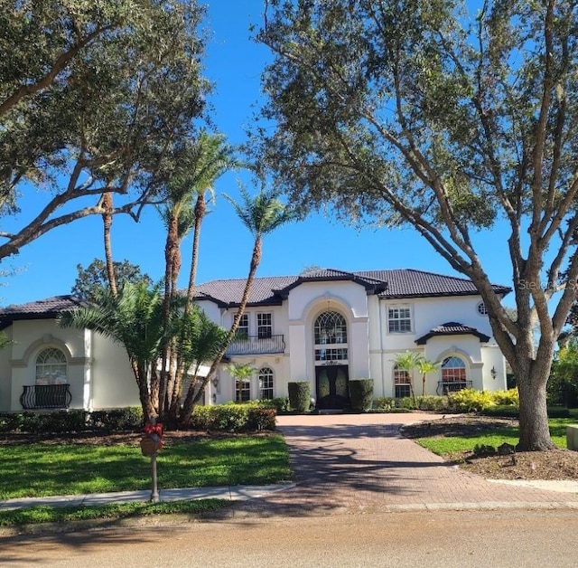 mediterranean / spanish house featuring a front lawn