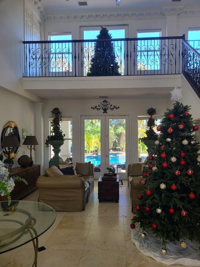 living room with light tile patterned flooring, french doors, and a high ceiling