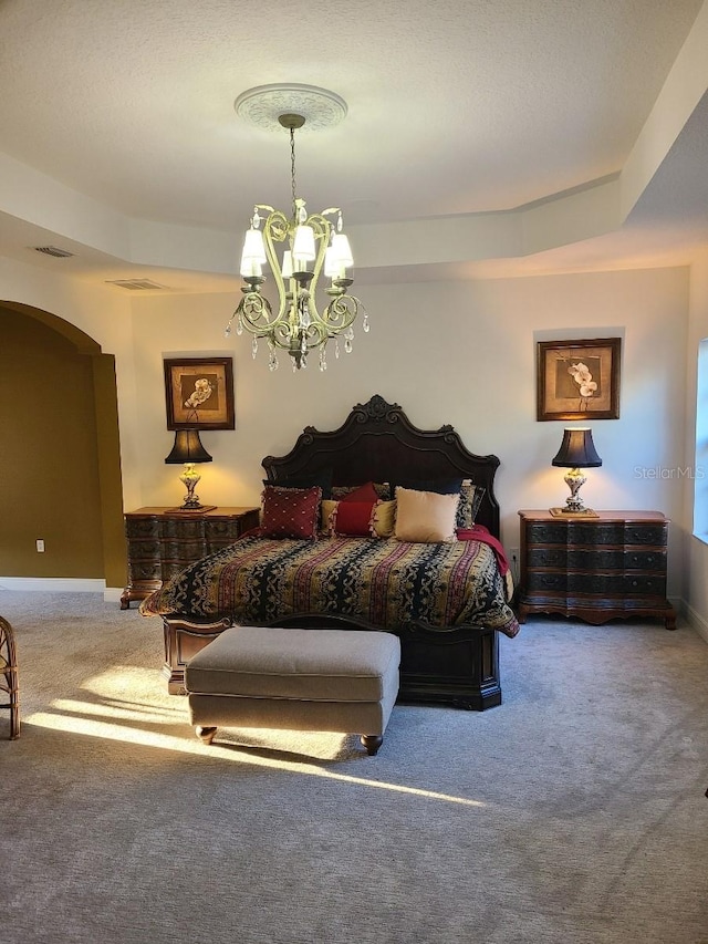 carpeted bedroom featuring an inviting chandelier