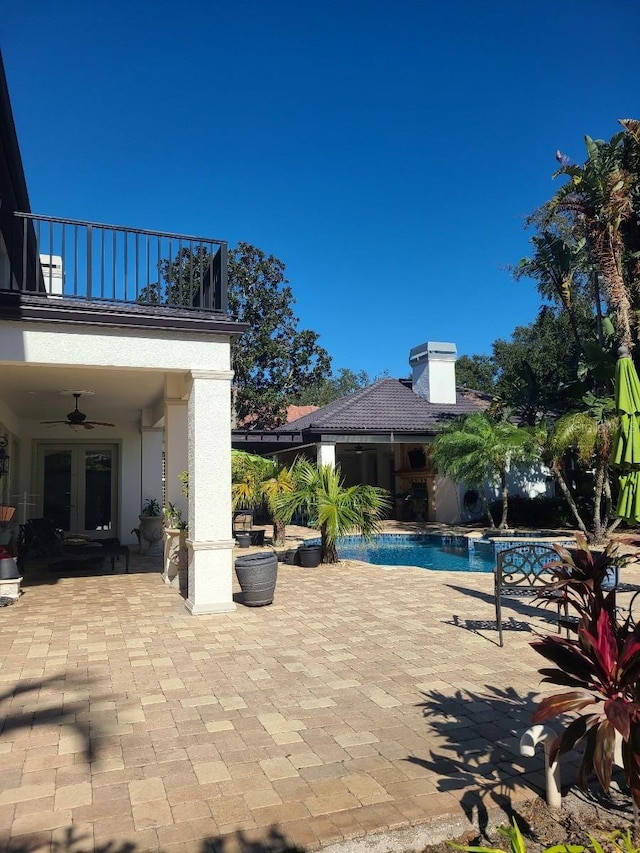 view of swimming pool featuring ceiling fan, french doors, and a patio