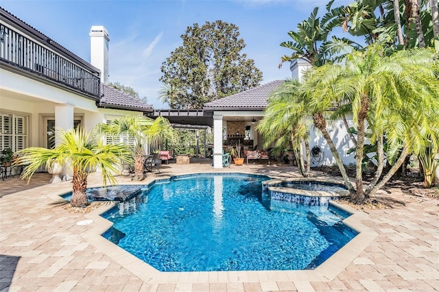 view of swimming pool with an in ground hot tub, ceiling fan, and a patio area