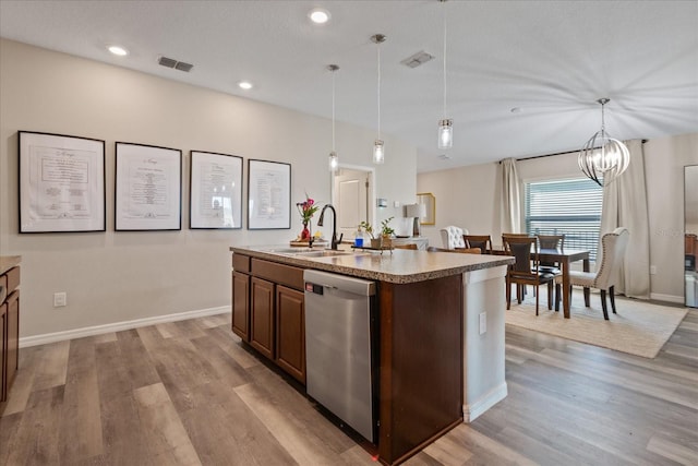 kitchen with a kitchen island with sink, sink, decorative light fixtures, dishwasher, and light hardwood / wood-style floors