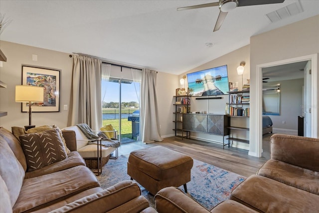 living room featuring ceiling fan, light hardwood / wood-style floors, and vaulted ceiling