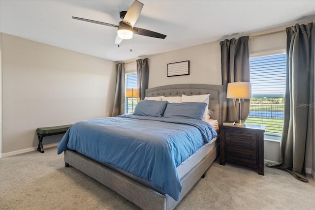 carpeted bedroom featuring multiple windows and ceiling fan