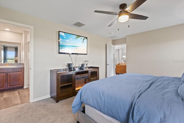 carpeted bedroom with connected bathroom and ceiling fan