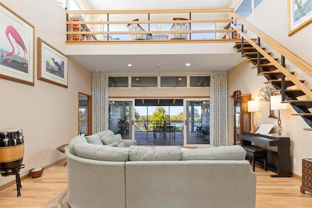 living room featuring light hardwood / wood-style floors and a high ceiling