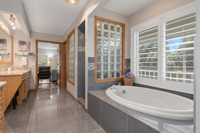 bathroom featuring vanity and tiled bath