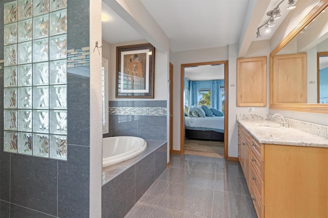 bathroom featuring vanity and a relaxing tiled tub