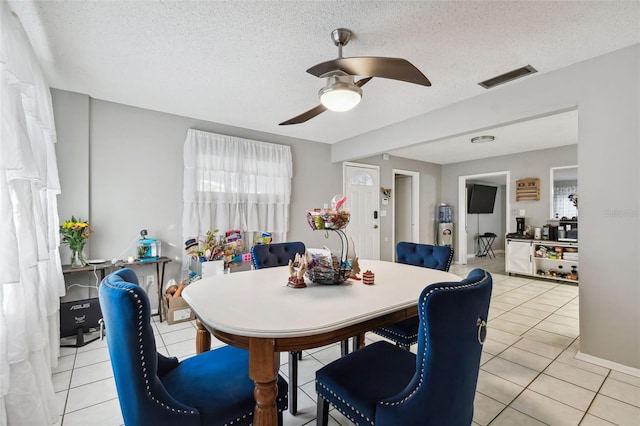 dining space with light tile patterned floors, a textured ceiling, and ceiling fan