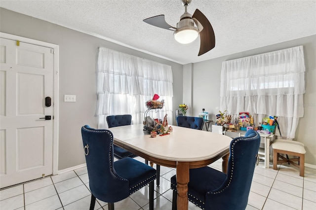 dining area featuring ceiling fan, light tile patterned floors, and a textured ceiling