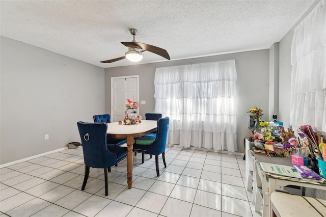 tiled dining room featuring ceiling fan and a textured ceiling