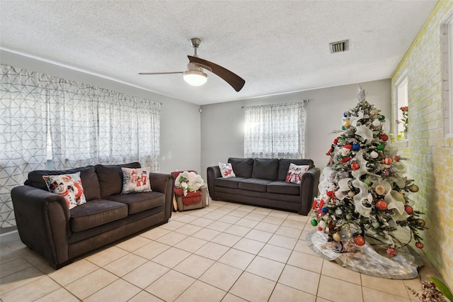 tiled living room with ceiling fan and a textured ceiling