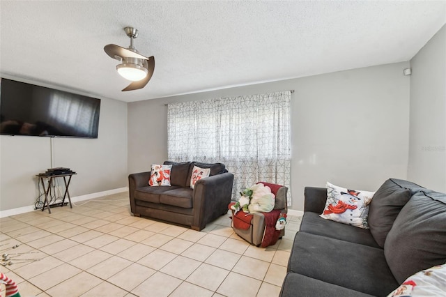 living room featuring ceiling fan, light tile patterned floors, and a textured ceiling