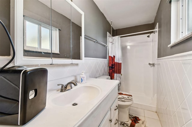 bathroom with a shower with curtain, vanity, tile walls, tile patterned flooring, and toilet