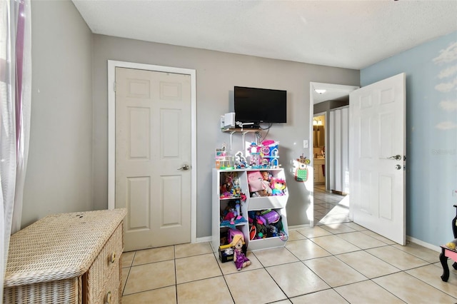 game room featuring light tile patterned floors and a textured ceiling