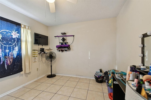 interior space featuring light tile patterned floors, a textured ceiling, and ceiling fan