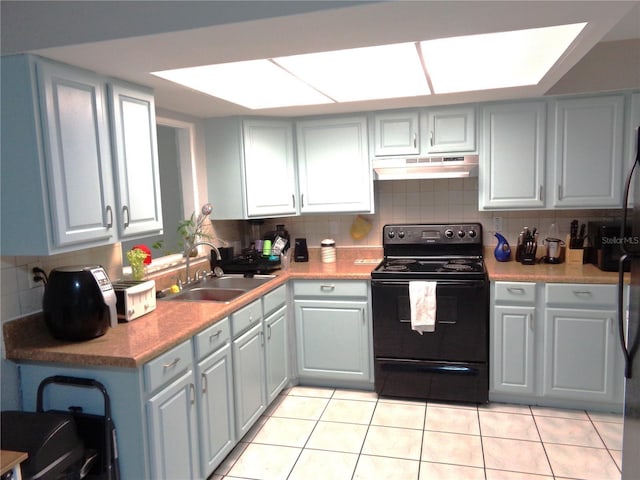 kitchen featuring light tile patterned floors, under cabinet range hood, a sink, black / electric stove, and backsplash