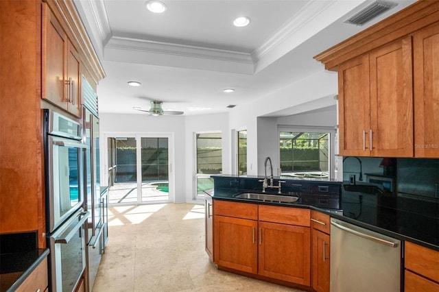 kitchen featuring crown molding, sink, a tray ceiling, and stainless steel appliances