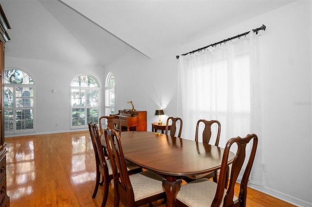 dining room with light hardwood / wood-style floors and lofted ceiling