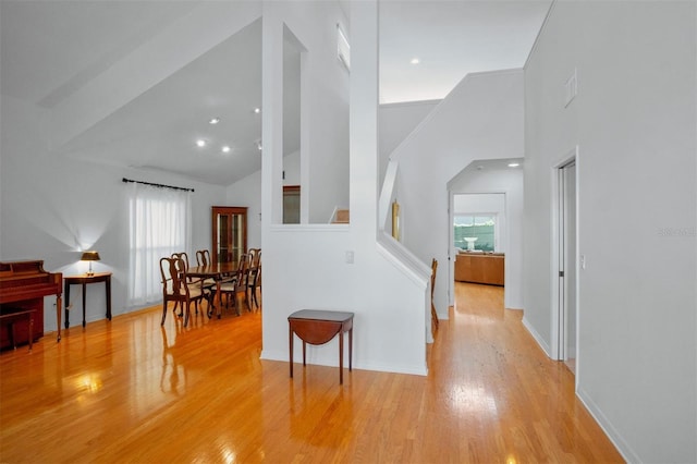 corridor featuring high vaulted ceiling and light hardwood / wood-style flooring