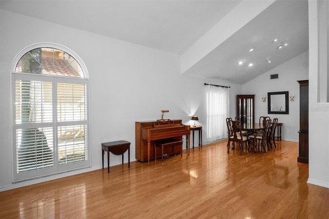 dining room featuring light wood-type flooring and high vaulted ceiling