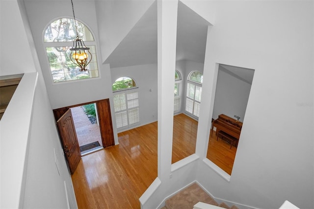 foyer featuring a high ceiling, light hardwood / wood-style floors, and an inviting chandelier