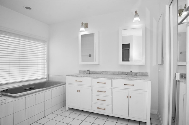 bathroom featuring tile patterned floors, vanity, and tiled tub