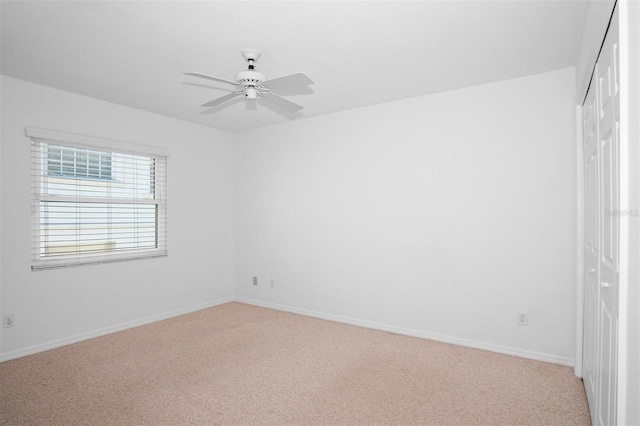 unfurnished bedroom with ceiling fan, a closet, and light colored carpet