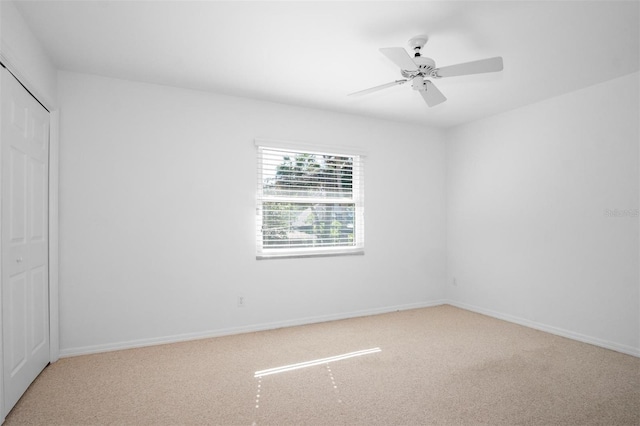 carpeted spare room featuring ceiling fan