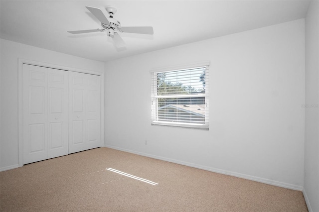 unfurnished bedroom featuring carpet, ceiling fan, and a closet