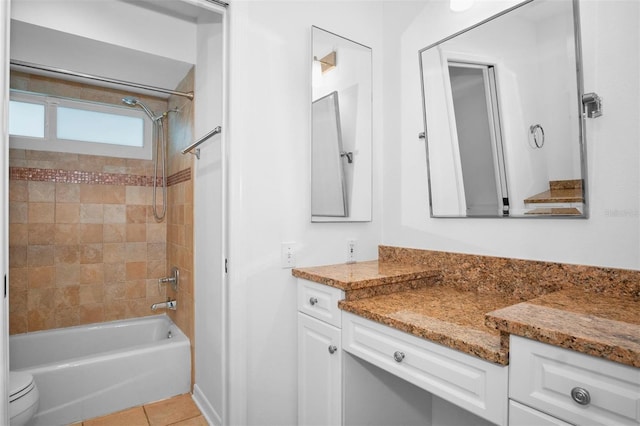 full bathroom with toilet, tile patterned flooring, vanity, and tiled shower / bath