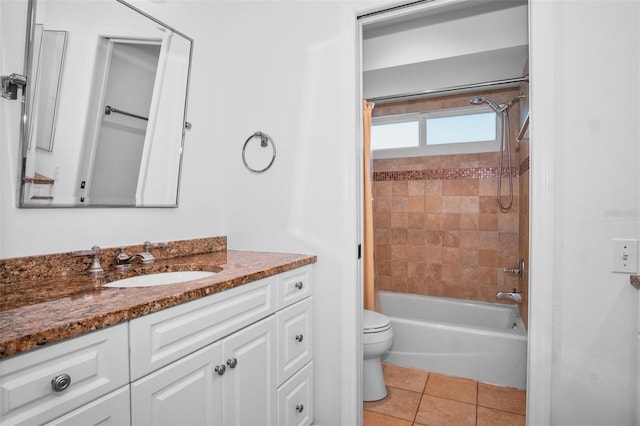 full bathroom featuring tile patterned flooring, vanity, tiled shower / bath combo, and toilet