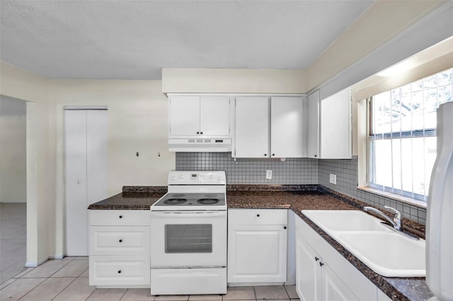 kitchen with white appliances, backsplash, sink, light tile patterned floors, and white cabinetry