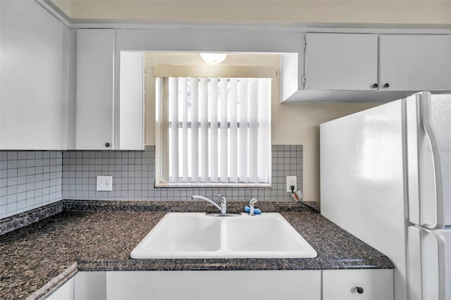 kitchen featuring backsplash, sink, white cabinets, and white refrigerator