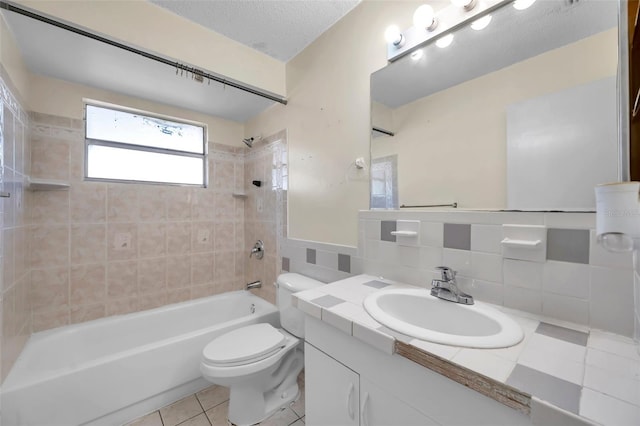 full bathroom with tile patterned flooring, a textured ceiling, toilet, tile walls, and tiled shower / bath