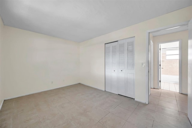 unfurnished bedroom with light tile patterned floors and a closet