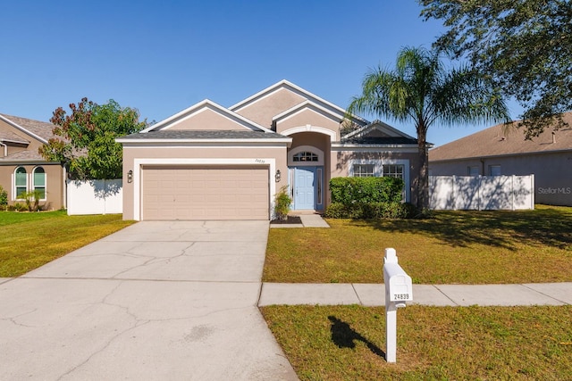 ranch-style house featuring a front lawn and a garage