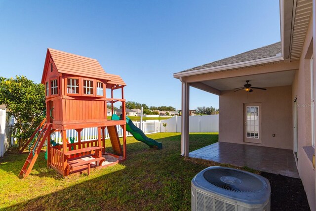 view of jungle gym featuring ceiling fan, cooling unit, a patio area, and a lawn