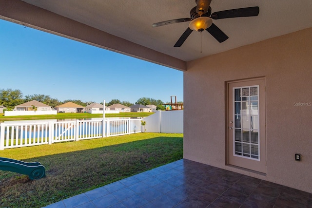 view of yard with ceiling fan, a patio area, and a water view