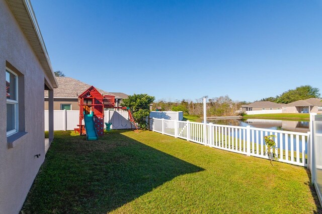 view of yard with a playground and a water view