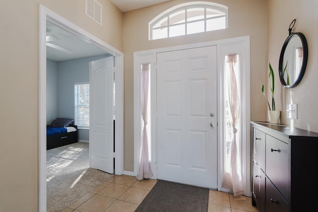 tiled foyer featuring ceiling fan