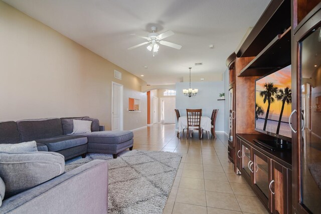 tiled living room featuring ceiling fan with notable chandelier