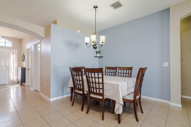 dining room with light tile patterned floors and a notable chandelier