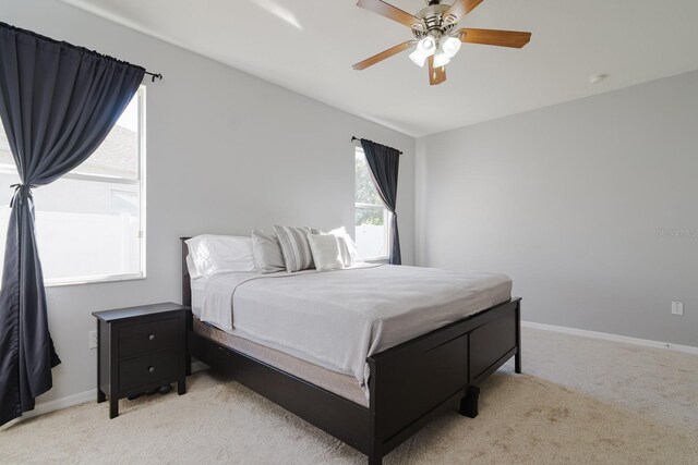 bedroom featuring light carpet and ceiling fan