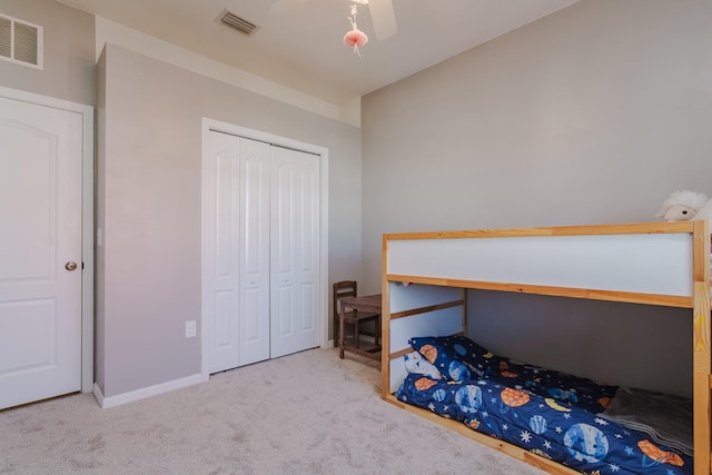 carpeted bedroom featuring ceiling fan and a closet