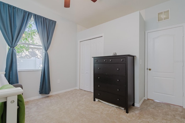 bedroom with ceiling fan, a closet, and light carpet