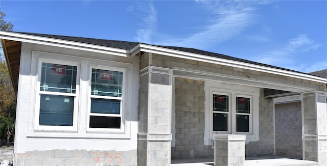 view of side of property featuring a shingled roof